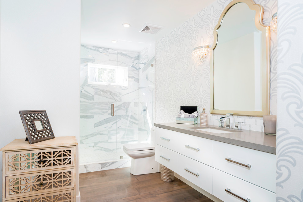 На фото: ванная комната в стиле неоклассика (современная классика) с врезной раковиной, плоскими фасадами, белыми фасадами, душем в нише, белой плиткой, паркетным полом среднего тона, серой столешницей и окном с