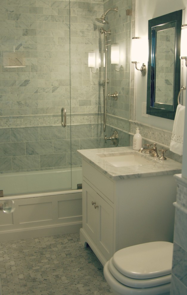 Aménagement d'une petite salle de bain principale classique avec un lavabo encastré, des portes de placard blanches, un plan de toilette en marbre, un combiné douche/baignoire, un carrelage blanc, un carrelage de pierre, un mur bleu, un sol en marbre et un placard avec porte à panneau encastré.