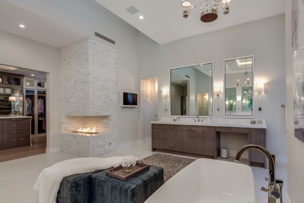 На фото: большая главная ванная комната в современном стиле с плоскими фасадами, фасадами цвета дерева среднего тона, отдельно стоящей ванной, бежевыми стенами, накладной раковиной и белым полом с