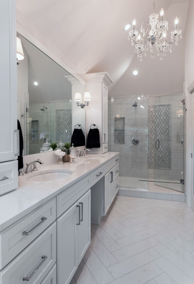 На фото: главная ванная комната среднего размера в классическом стиле с белыми фасадами, ванной на ножках, двойным душем, раздельным унитазом, белой плиткой, керамогранитной плиткой, серыми стенами, полом из керамогранита, врезной раковиной, столешницей из искусственного камня, белым полом, душем с распашными дверями, белой столешницей, нишей, тумбой под две раковины, встроенной тумбой, многоуровневым потолком и фасадами с утопленной филенкой