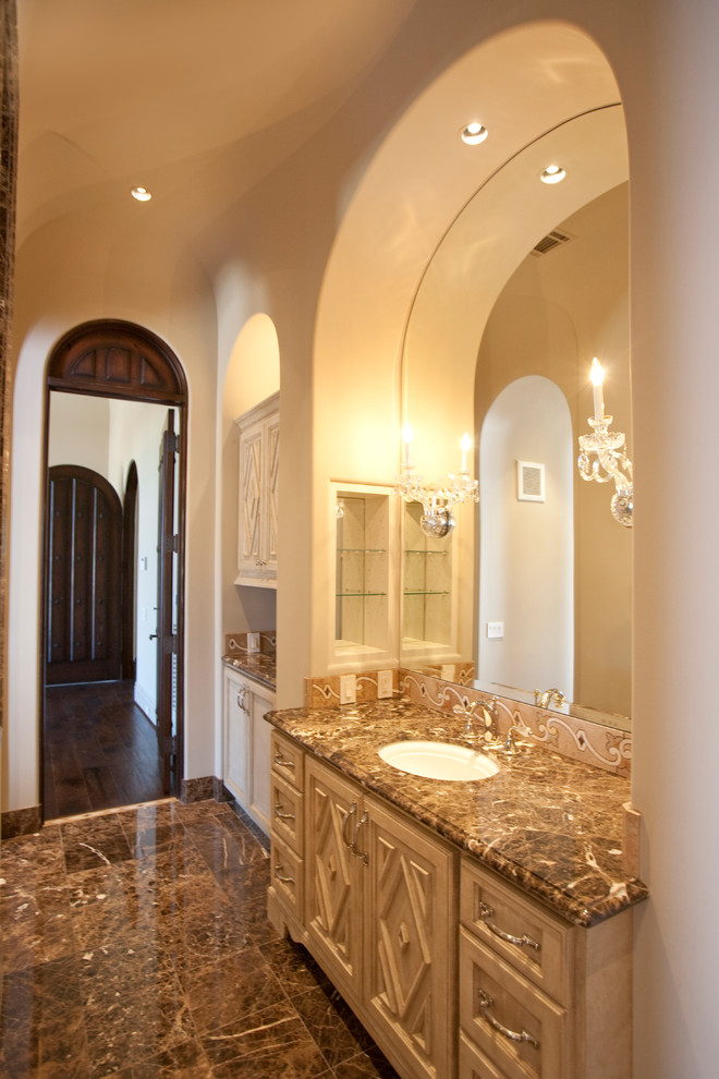 Idéer för att renovera ett mycket stort medelhavsstil en-suite badrum, med ett nedsänkt handfat, möbel-liknande, beige skåp, marmorbänkskiva, ett fristående badkar, en dusch i en alkov, en toalettstol med separat cisternkåpa, brun kakel, stenkakel, beige väggar och marmorgolv