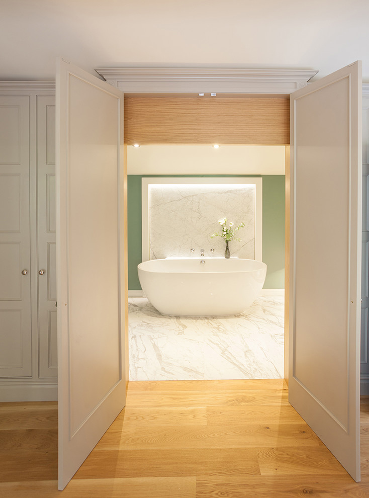 Medium sized contemporary ensuite bathroom in Edinburgh with freestanding cabinets, white cabinets, a freestanding bath, a one-piece toilet, grey tiles, porcelain tiles, green walls, porcelain flooring, a built-in sink and marble worktops.