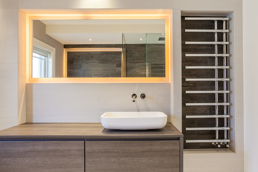 This is an example of a contemporary bathroom in Dublin with medium wood cabinets.