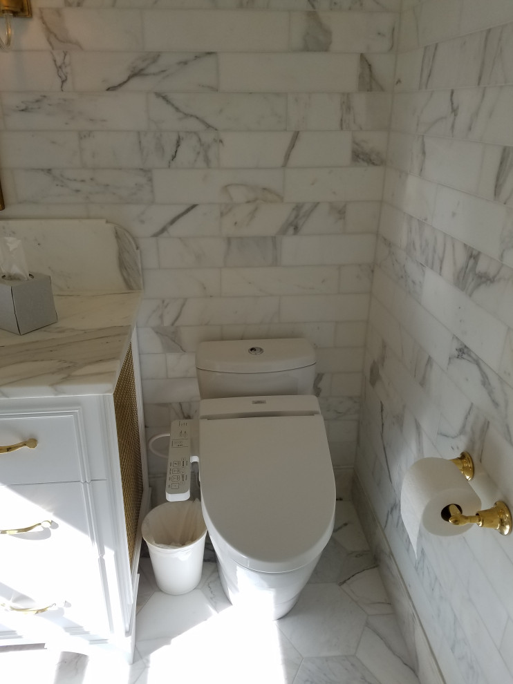 Cette image montre une salle de bain principale victorienne de taille moyenne avec un placard en trompe-l'oeil, des portes de placard blanches, une baignoire encastrée, un combiné douche/baignoire, un bidet, un carrelage blanc, du carrelage en marbre, un mur blanc, un sol en marbre, un lavabo encastré, un plan de toilette en marbre, un sol blanc, une cabine de douche à porte battante et un plan de toilette blanc.