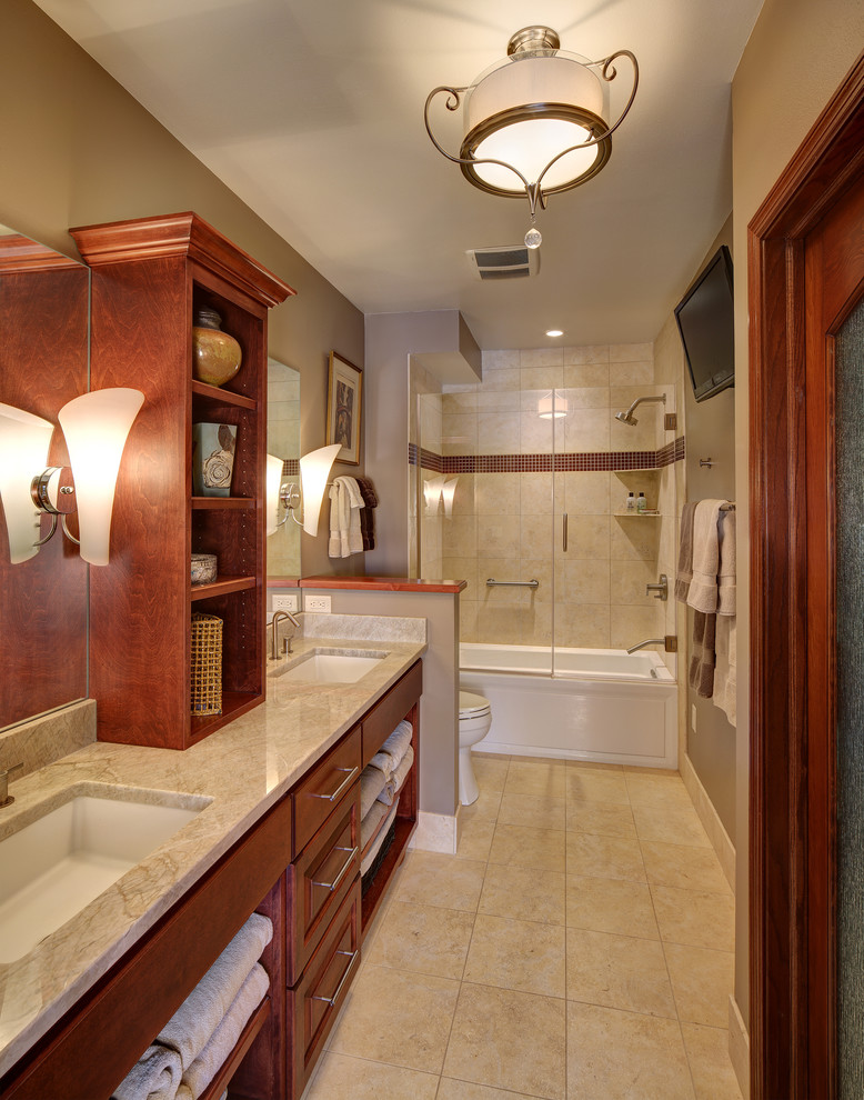 Classic ensuite bathroom in Milwaukee with a submerged sink, freestanding cabinets, medium wood cabinets, quartz worktops, an alcove bath, an alcove shower, a two-piece toilet, beige tiles, stone tiles and limestone flooring.