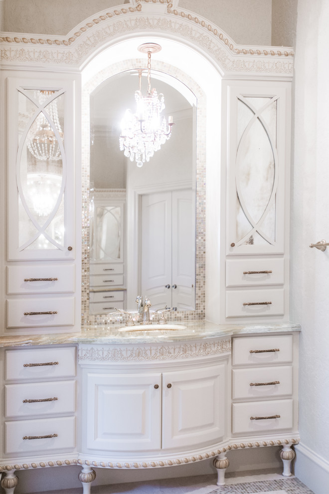 Idee per una grande stanza da bagno padronale classica con ante lisce, ante bianche, vasca freestanding, piastrelle beige, piastrelle di vetro, pareti beige, pavimento in travertino, lavabo sottopiano e top in marmo