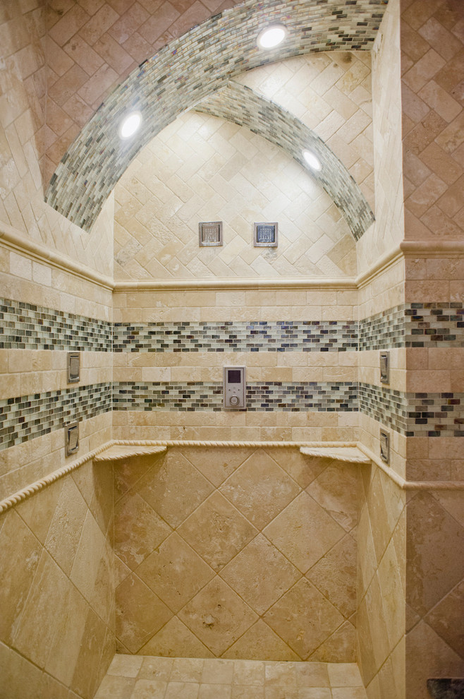 Klassisk inredning av ett litet badrum med dusch, med luckor med upphöjd panel, skåp i slitet trä, en jacuzzi, en öppen dusch, en toalettstol med hel cisternkåpa, flerfärgad kakel, glasskiva, beige väggar, travertin golv, ett fristående handfat och granitbänkskiva