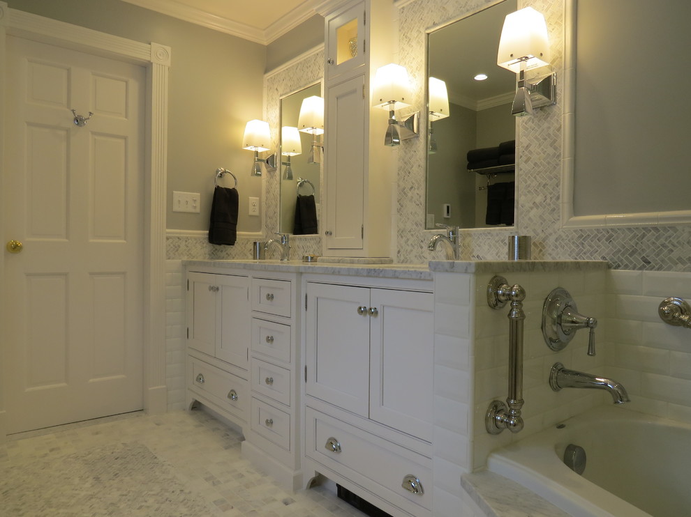 Aménagement d'une salle de bain principale classique de taille moyenne avec un lavabo encastré, des portes de placard blanches, un plan de toilette en marbre, une baignoire en alcôve, une douche à l'italienne, un carrelage blanc, un carrelage métro, un mur gris, un sol en marbre et un placard avec porte à panneau encastré.