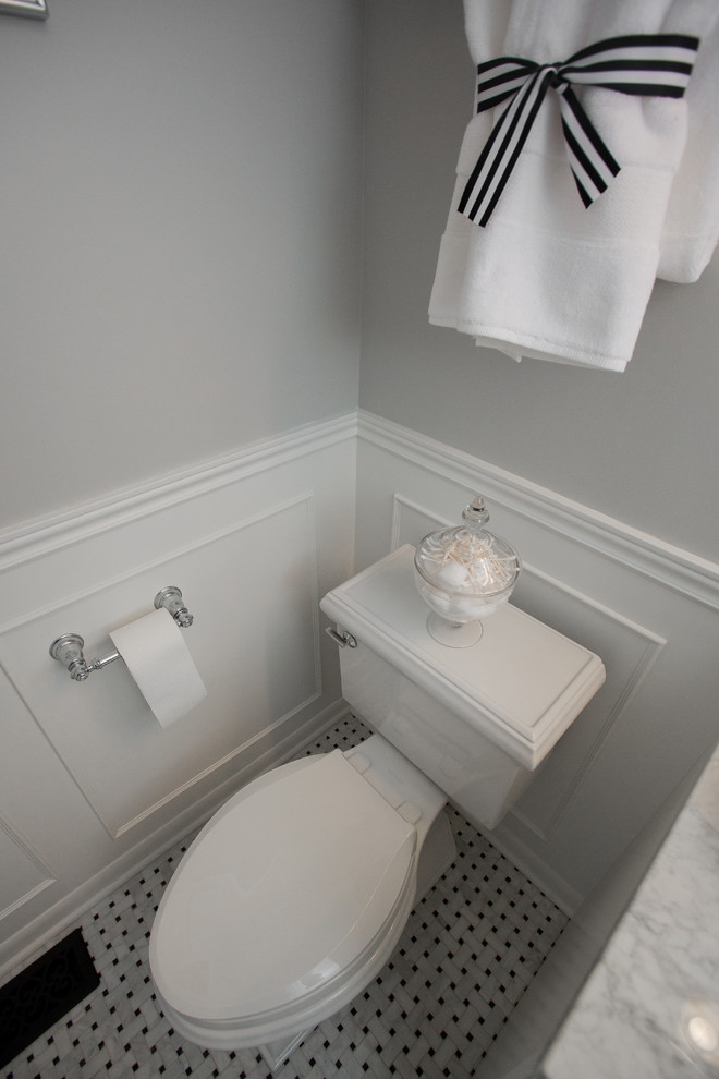 Idee per una stanza da bagno con ante con riquadro incassato, WC monopezzo, pareti grigie, lavabo da incasso e top in marmo