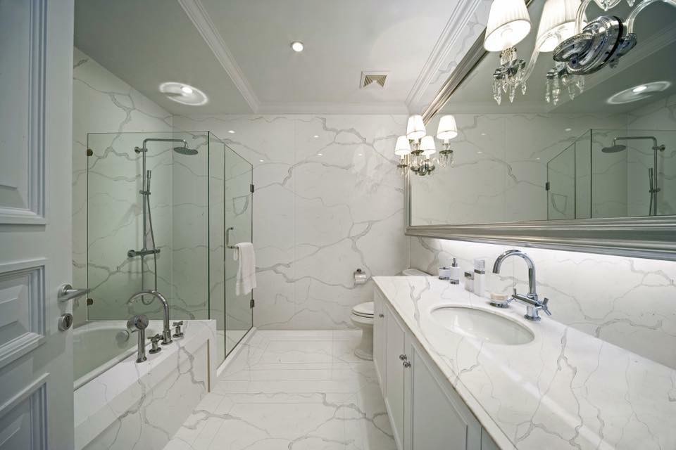 This is an example of an expansive mediterranean ensuite bathroom in Miami with raised-panel cabinets, white cabinets, a built-in bath, a corner shower, a one-piece toilet, a submerged sink and a hinged door.