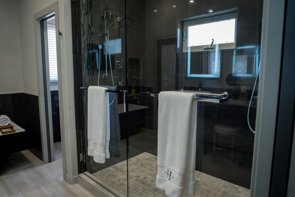 Photo of a large modern ensuite bathroom in Denver with flat-panel cabinets, dark wood cabinets, a freestanding bath, a double shower, a one-piece toilet, black tiles, mosaic tiles, grey walls, porcelain flooring, a vessel sink and engineered stone worktops.