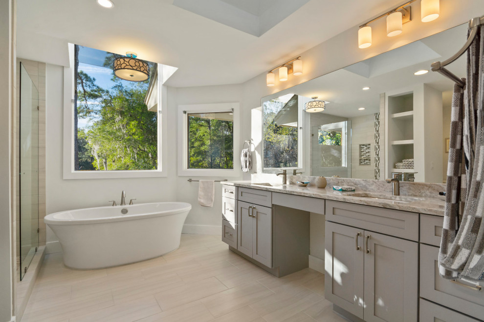 Klassisk inredning av ett stort grå grått en-suite badrum, med ett fristående badkar, flerfärgad kakel, keramikplattor, bänkskiva i kvarts, en dusch i en alkov, med dusch som är öppen, en toalettstol med hel cisternkåpa, ett undermonterad handfat, vita väggar och beiget golv