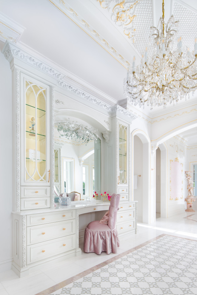 Klassisk inredning av ett stort vit vitt en-suite badrum, med luckor med infälld panel, vita skåp, vit kakel, marmorkakel, marmorgolv, marmorbänkskiva och vitt golv