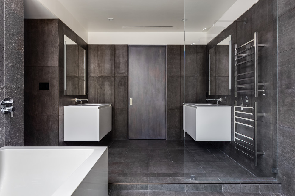 На фото: главная ванная комната в стиле модернизм с плоскими фасадами, белыми фасадами, душем без бортиков, серой плиткой, подвесной раковиной, серым полом, открытым душем и белой столешницей