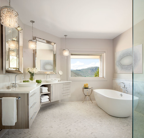 Luxury bathroom with floating wood bathroom cabinets, double sinks, large mirrors, pendant lights, and a freestanding bathtub near a window with mountain view.