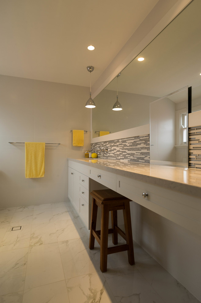 Пример оригинального дизайна: ванная комната в стиле неоклассика (современная классика) с накладной раковиной, фасадами в стиле шейкер, белыми фасадами, унитазом-моноблоком и каменной плиткой