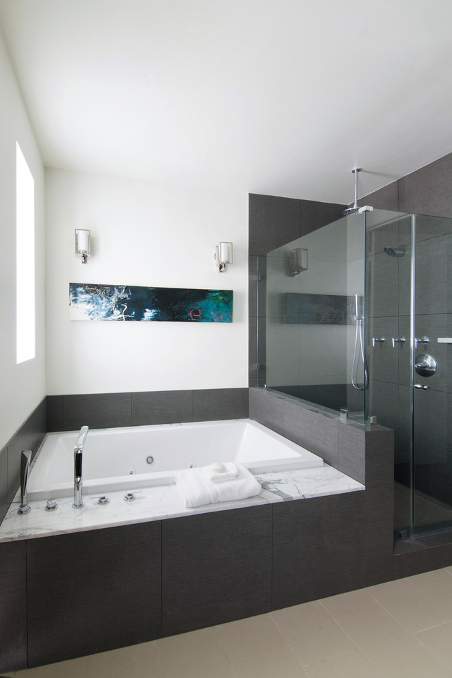 Идея дизайна: ванная комната в современном стиле с врезной раковиной, фасадами островного типа, темными деревянными фасадами, мраморной столешницей, гидромассажной ванной, двойным душем, серой плиткой и каменной плиткой