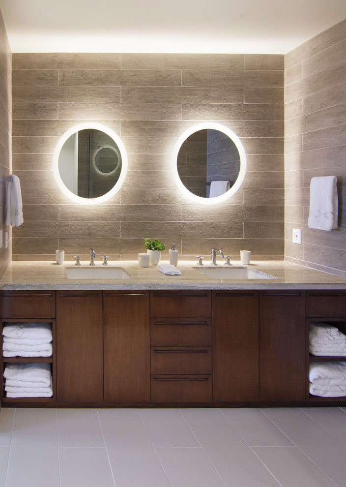 Свежая идея для дизайна: ванная комната в современном стиле с врезной раковиной, плоскими фасадами, темными деревянными фасадами, серой плиткой, столешницей из известняка и керамической плиткой - отличное фото интерьера