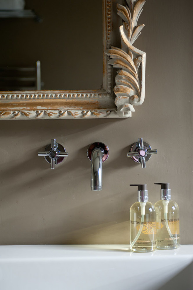 Foto på ett funkis badrum, med ett fristående badkar, en dubbeldusch, bruna väggar och marmorgolv