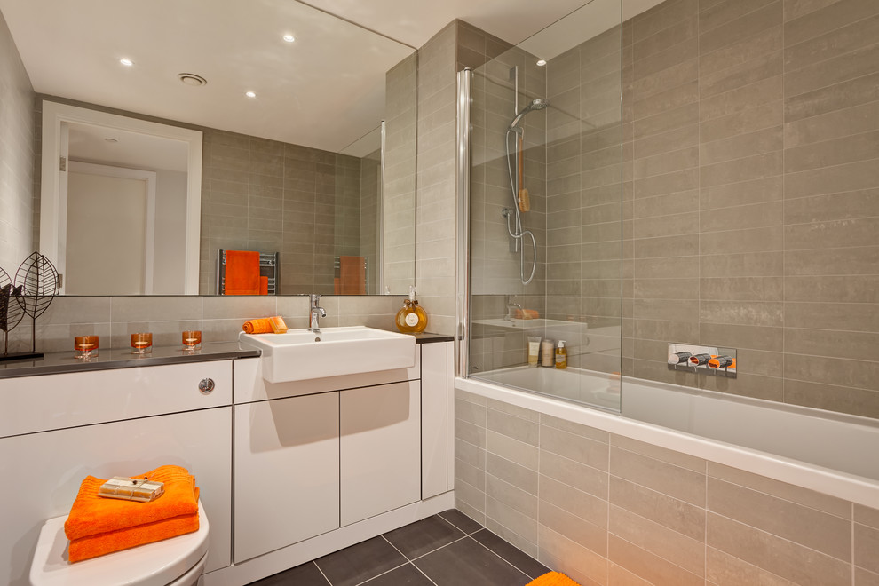 Design ideas for a contemporary bathroom in Cambridgeshire with an alcove bath, a shower/bath combination, grey tiles and grey floors.