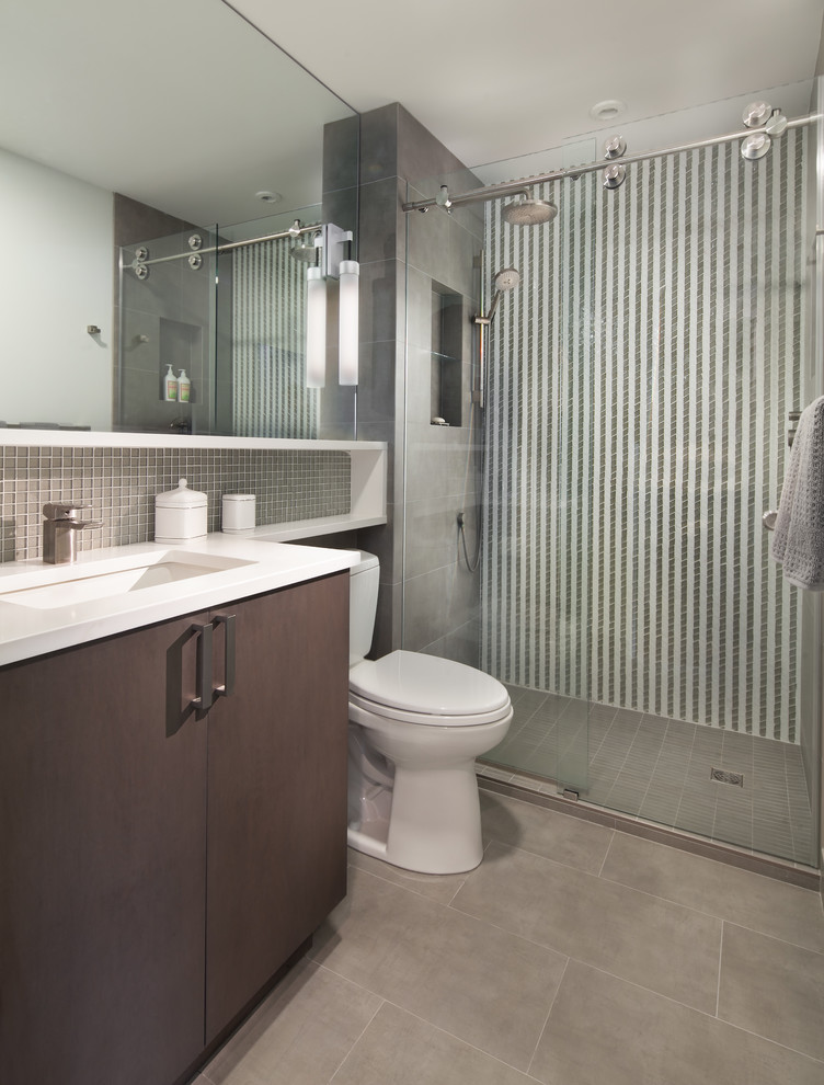 Inspiration for a medium sized contemporary ensuite bathroom in DC Metro with flat-panel cabinets, brown cabinets, an alcove shower, a two-piece toilet, white walls, a submerged sink, grey tiles, ceramic tiles, vinyl flooring and solid surface worktops.
