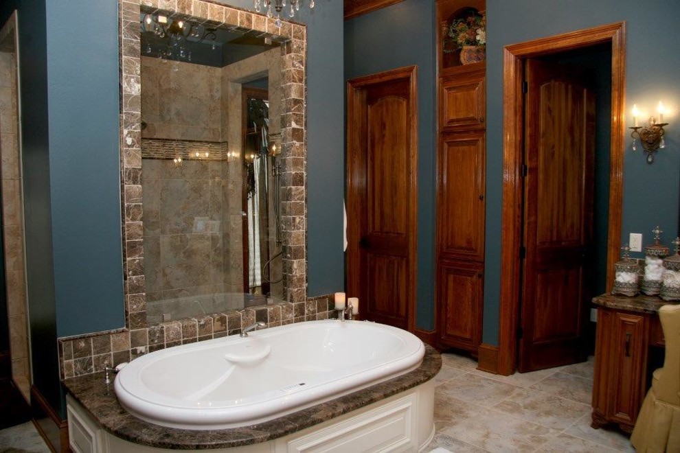 Medium sized traditional ensuite bathroom in New Orleans with medium wood cabinets, granite worktops, a built-in bath, a walk-in shower, beige tiles, ceramic tiles, blue walls, raised-panel cabinets and travertine flooring.