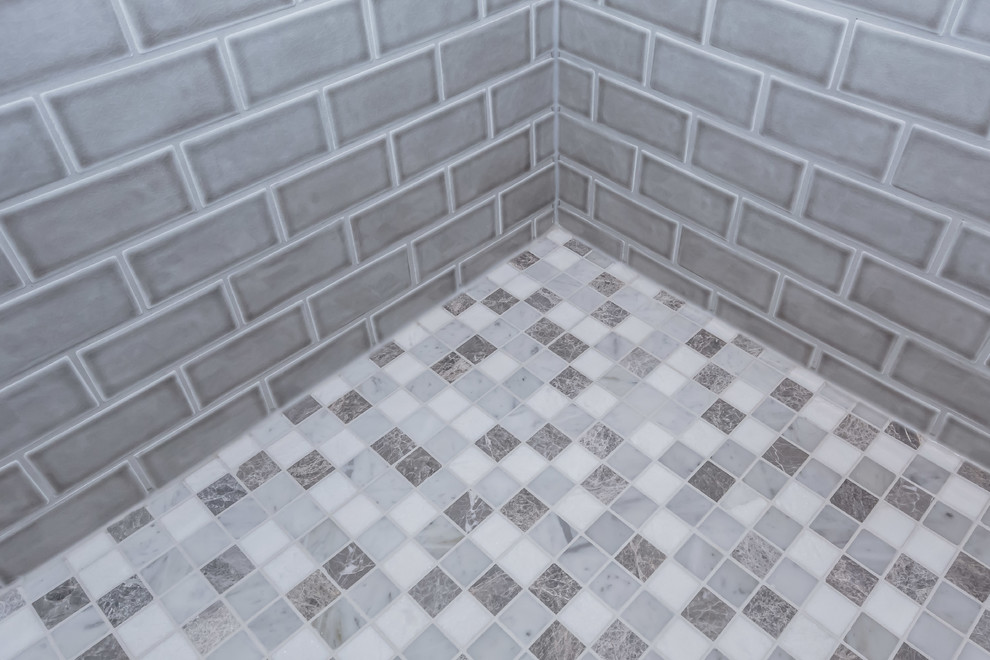 Bild på ett litet funkis badrum, med en dusch i en alkov, grå kakel, porslinskakel, klinkergolv i porslin, flerfärgat golv och dusch med gångjärnsdörr