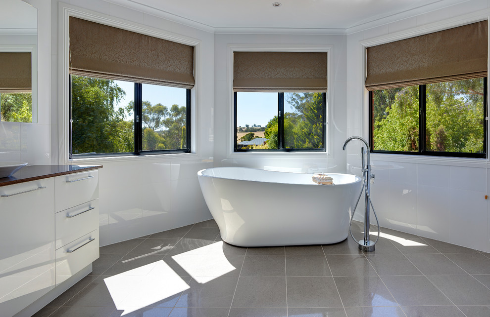 Стильный дизайн: большая главная ванная комната в современном стиле с настольной раковиной, отдельно стоящей ванной и открытым душем - последний тренд