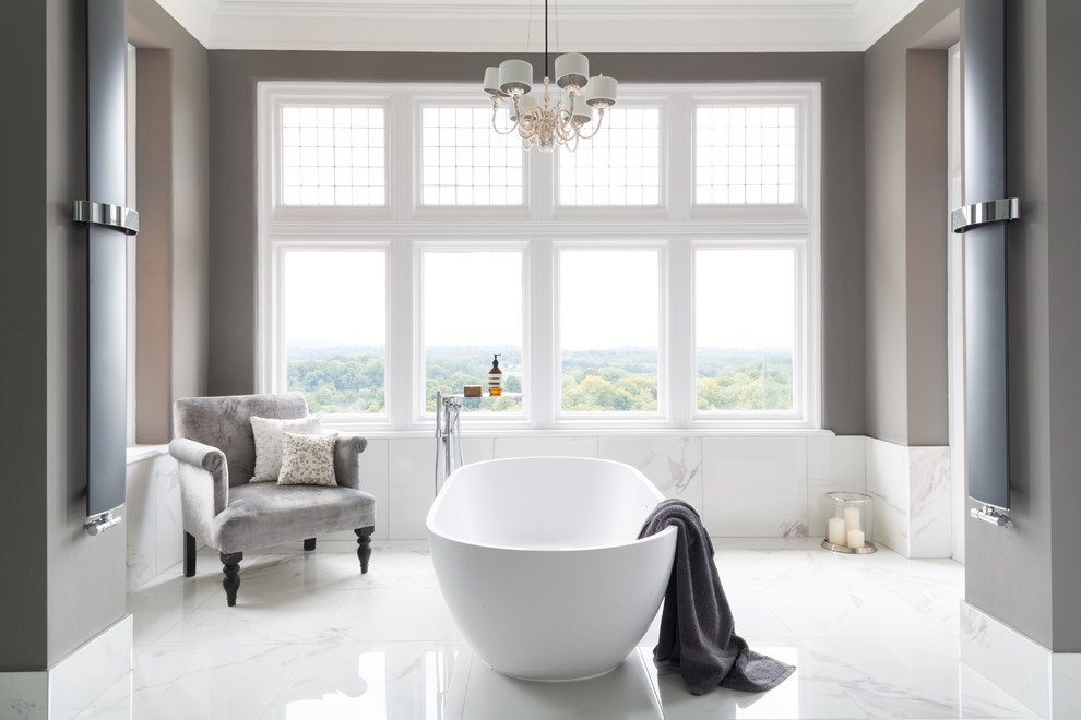 На фото: большая ванная комната в современном стиле с отдельно стоящей ванной и серыми стенами с