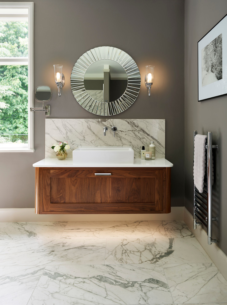 Réalisation d'une salle de bain principale tradition en bois brun avec un placard à porte shaker, un mur gris, une vasque et un sol en marbre.