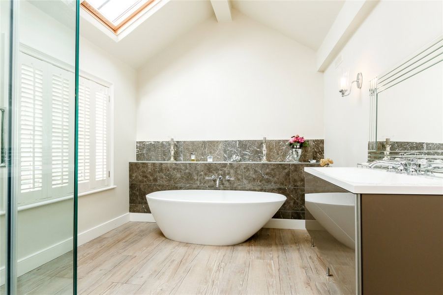 Photo of a medium sized modern ensuite bathroom in Devon with freestanding cabinets, beige cabinets, a freestanding bath, a walk-in shower, brown tiles, white walls, vinyl flooring and a built-in sink.