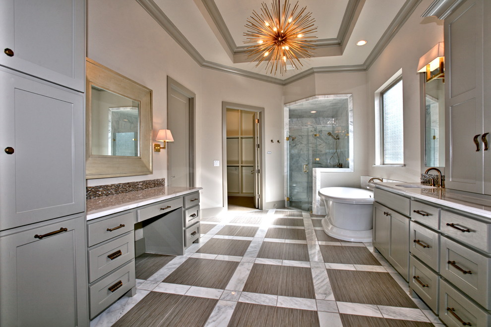 На фото: огромная главная ванная комната в стиле неоклассика (современная классика) с врезной раковиной, фасадами в стиле шейкер, серыми фасадами, мраморной столешницей, отдельно стоящей ванной, душем в нише, раздельным унитазом, серой плиткой, стеклянной плиткой, бежевыми стенами и мраморным полом