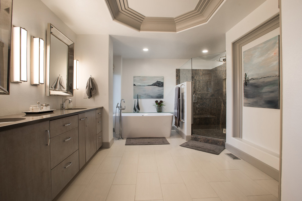 Cette image montre une grande salle de bain principale design avec un placard à porte plane, une baignoire indépendante, une douche double, WC à poser, un carrelage gris, des carreaux de céramique, un mur blanc, un sol en carrelage de porcelaine et un plan de toilette en quartz modifié.