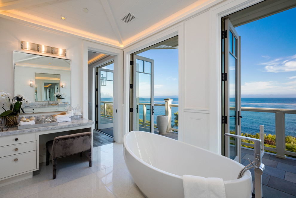 Maritimes Badezimmer En Suite mit weißen Schränken, freistehender Badewanne, weißer Wandfarbe und weißem Boden in Los Angeles