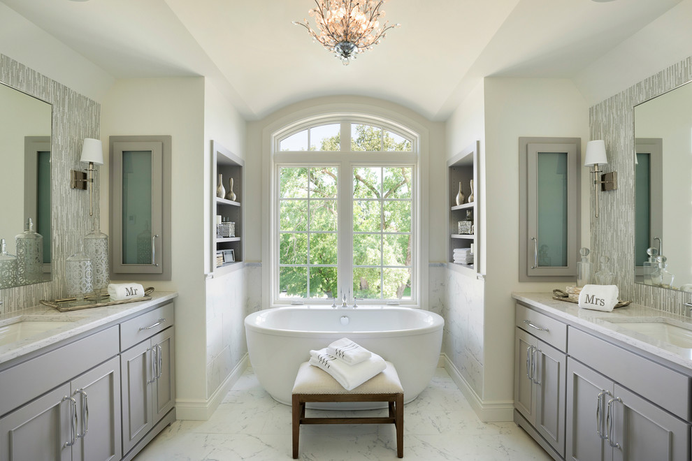 Exempel på ett stort klassiskt en-suite badrum, med luckor med infälld panel, grå skåp, ett fristående badkar, grå kakel, vita väggar, klinkergolv i keramik, ett undermonterad handfat och vitt golv