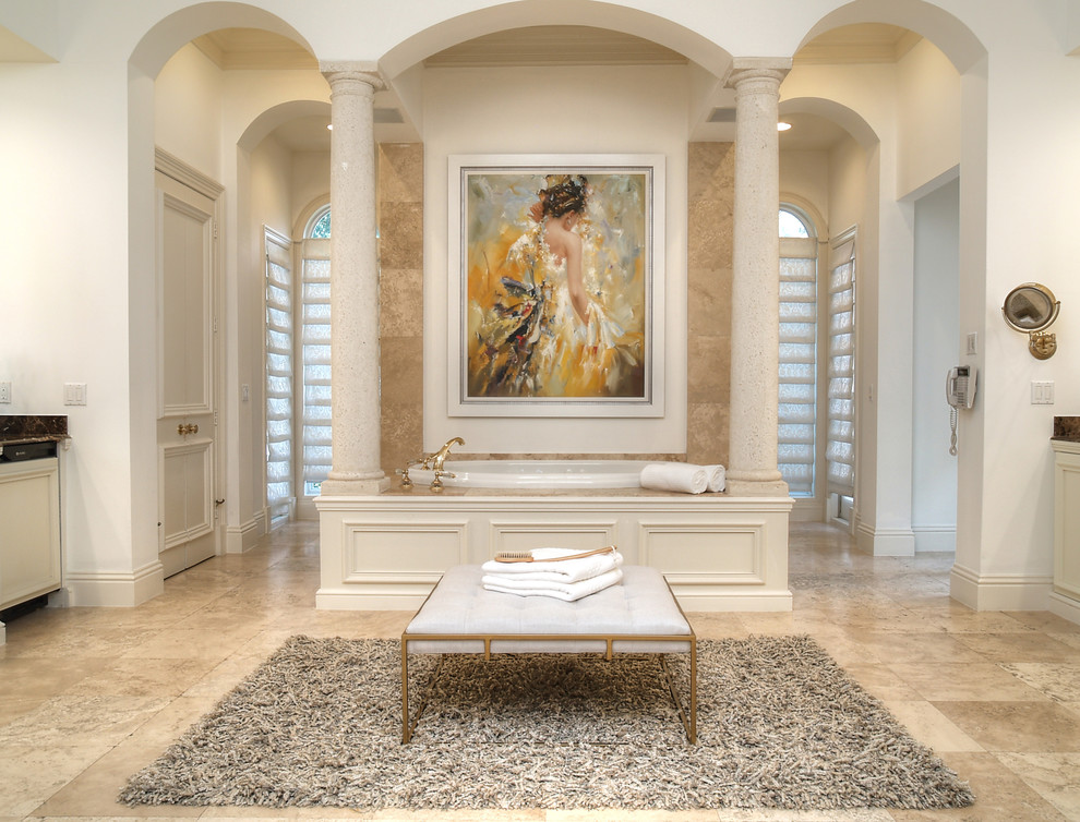 Cette photo montre une salle de bain principale chic avec un sol en carrelage de céramique, un sol beige, un placard avec porte à panneau encastré, des portes de placard beiges, une baignoire posée, un carrelage beige, un mur blanc et un plan de toilette beige.
