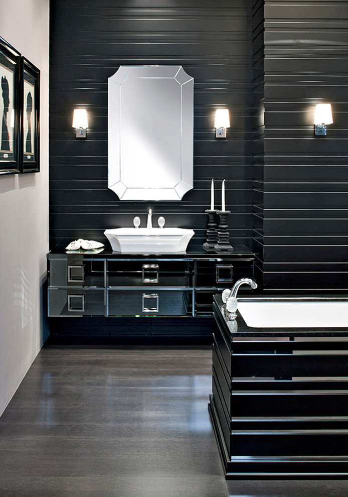 ニューヨークにある高級な広いコンテンポラリースタイルのおしゃれなマスターバスルーム (ベッセル式洗面器、ガラス扉のキャビネット、黒いキャビネット、ガラスの洗面台、置き型浴槽) の写真