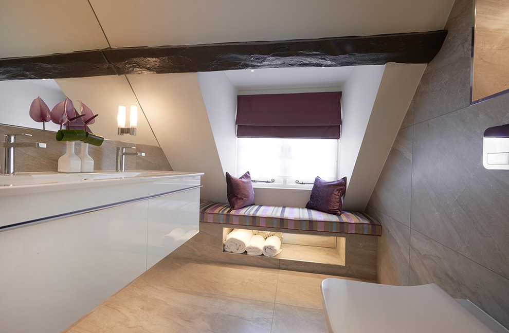 Cette image montre une salle de bain design de taille moyenne avec WC suspendus, un mur gris et un sol en carrelage de céramique.