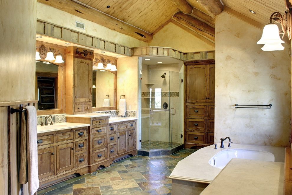 Inspiration för mellanstora rustika en-suite badrum, med luckor med infälld panel, bruna skåp, ett fristående badkar, en dusch i en alkov, beige väggar, skiffergolv, ett undermonterad handfat, granitbänkskiva, flerfärgat golv och dusch med gångjärnsdörr