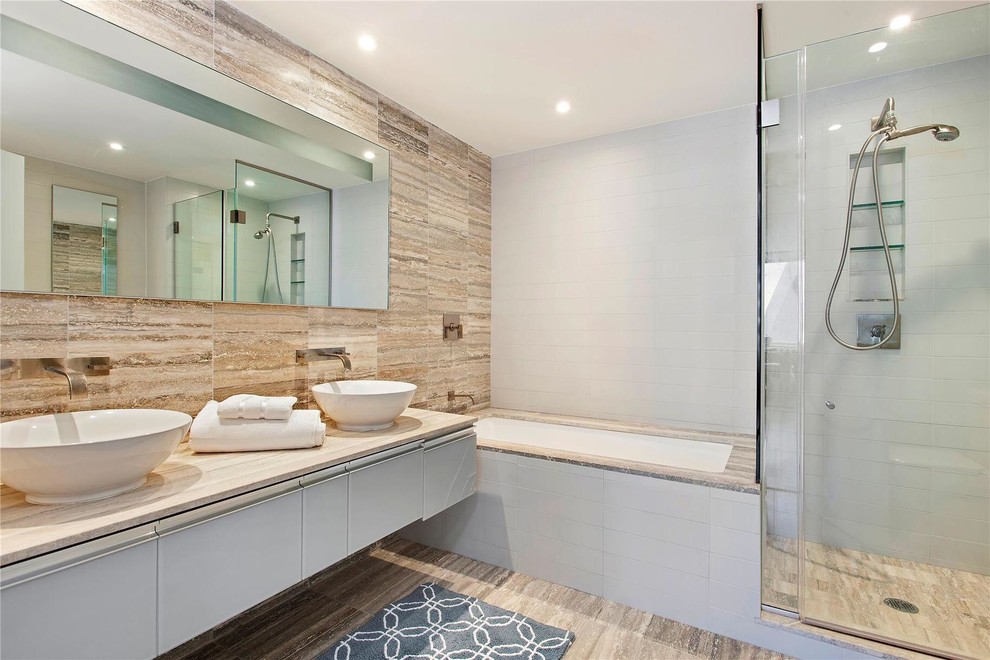 Imagen de cuarto de baño contemporáneo con lavabo sobreencimera, armarios con paneles lisos, puertas de armario blancas, bañera encastrada sin remate, ducha esquinera y baldosas y/o azulejos beige