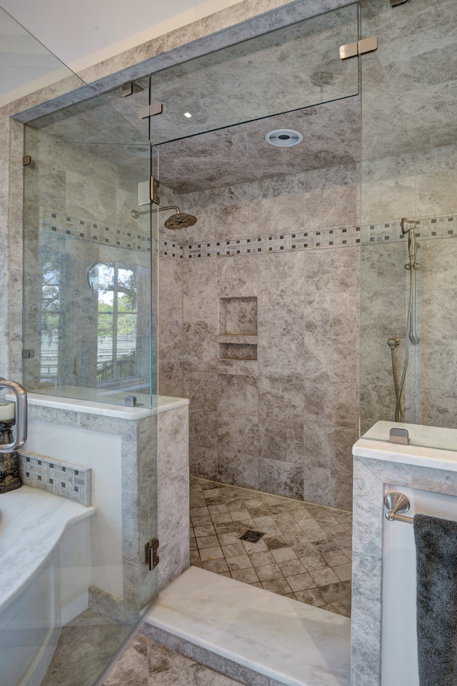Immagine di una grande stanza da bagno padronale tradizionale con lavabo sottopiano, ante con finitura invecchiata, top in marmo, doccia alcova, piastrelle beige, piastrelle in pietra e pareti beige