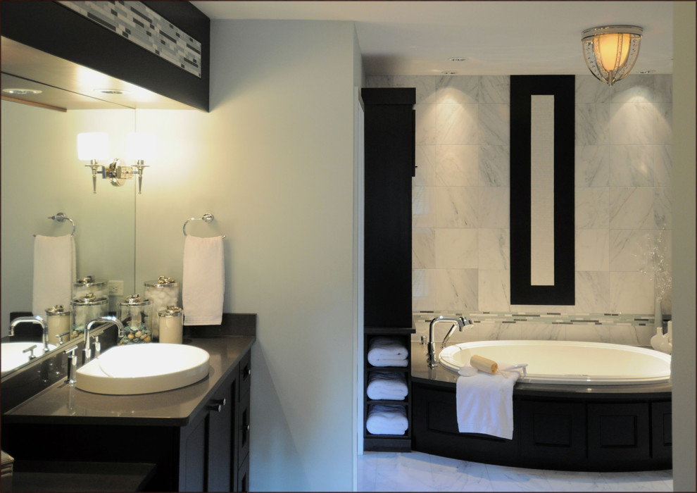 Immagine di una stanza da bagno padronale design con lavabo a bacinella, ante con riquadro incassato, ante nere, vasca da incasso e pareti grigie