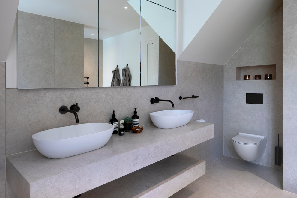 Inspiration för stora moderna vitt en-suite badrum, med släta luckor, vita skåp, ett fristående badkar, en öppen dusch, en vägghängd toalettstol, porslinskakel, vita väggar, klinkergolv i porslin, ett avlångt handfat, kaklad bänkskiva, vitt golv och med dusch som är öppen