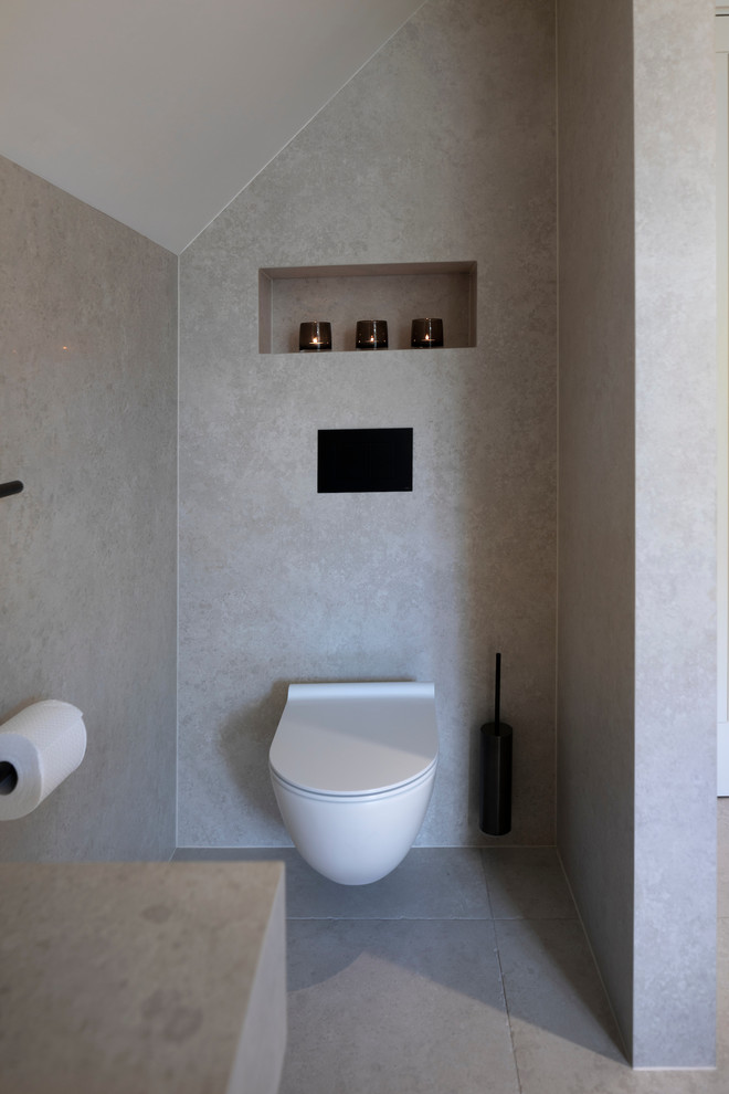 Inspiration for a large contemporary ensuite bathroom in Cheshire with flat-panel cabinets, white cabinets, a freestanding bath, a walk-in shower, a wall mounted toilet, porcelain tiles, white walls, porcelain flooring, a trough sink, tiled worktops, white floors, an open shower and white worktops.