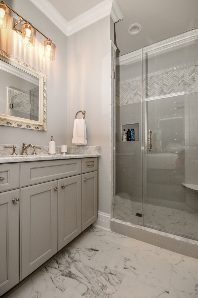 Foto på ett stort vintage badrum med dusch, med luckor med infälld panel, vita skåp, en dusch i en alkov, en toalettstol med separat cisternkåpa, grå väggar, ett undermonterad handfat, granitbänkskiva och dusch med skjutdörr