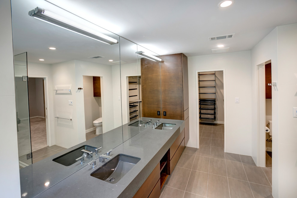 Inspiration for a mid-sized master ceramic tile and gray floor corner shower remodel in Austin with flat-panel cabinets, brown cabinets, white walls, an undermount sink, soapstone countertops and a hinged shower door