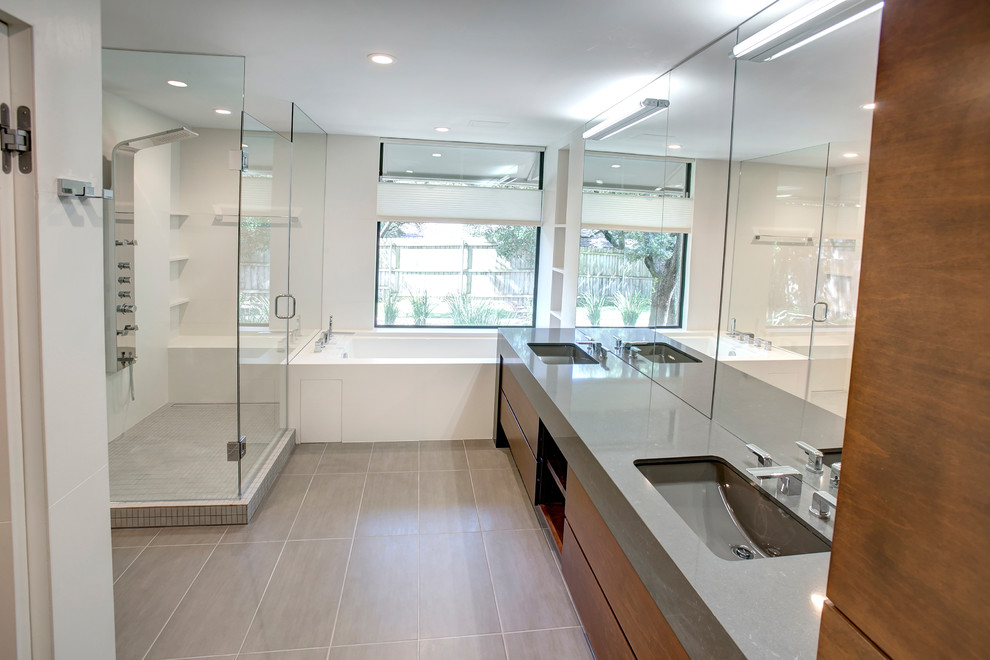 This is an example of a medium sized ensuite bathroom in Austin with flat-panel cabinets, brown cabinets, a corner shower, white walls, ceramic flooring, a submerged sink, soapstone worktops, grey floors and a hinged door.