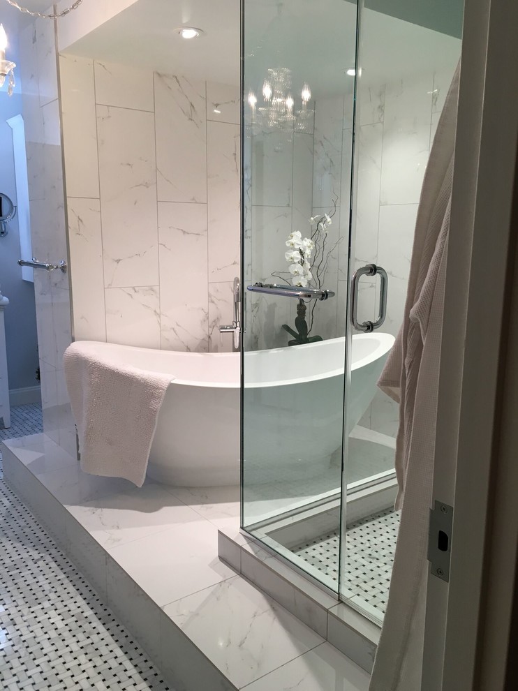This is an example of a large traditional ensuite bathroom in New York with shaker cabinets, white cabinets, a freestanding bath, a corner shower, white tiles, marble tiles, white walls, mosaic tile flooring, a submerged sink and granite worktops.