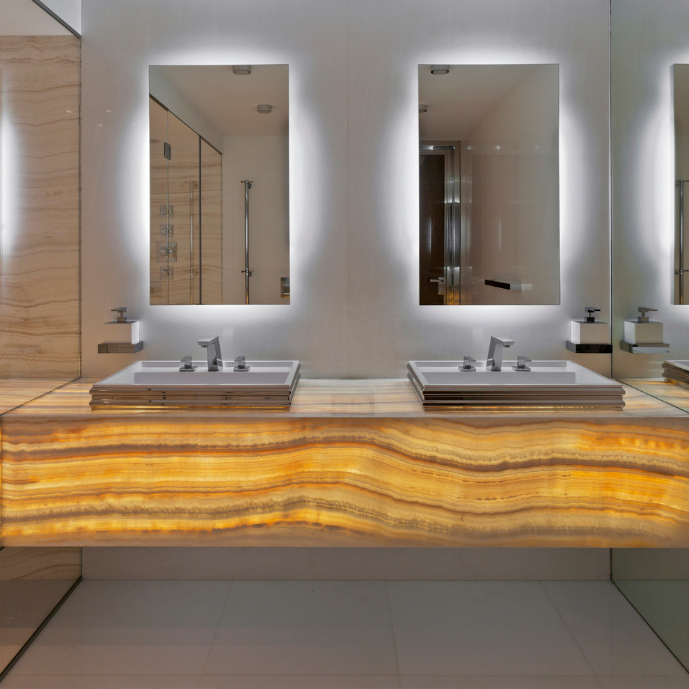 Inspiration for a large contemporary master white tile and stone slab marble floor doorless shower remodel in New York with white walls, onyx countertops, a drop-in sink, flat-panel cabinets and orange cabinets