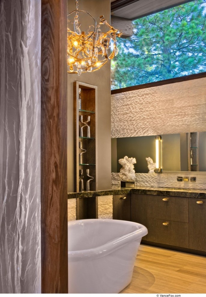 Exempel på ett mellanstort modernt en-suite badrum, med ett fristående badkar och ljust trägolv